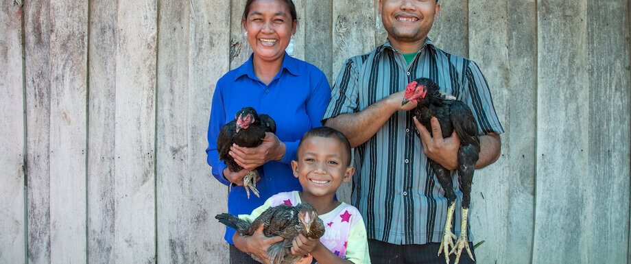 Heifer International -Cambodia, December 2015. Income II Project. Klang Savuth (43) (left), Kid Moa (43) and their son Ky Damkoeung (6) pose for a photo outside their home on December 08, 2015 in Kok Romeat Village, Cambodia.
