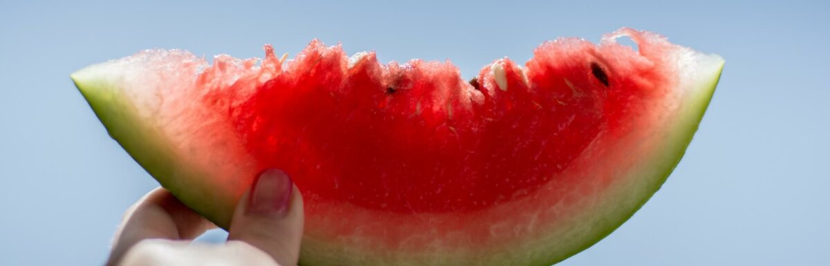 person holding watermelon to sky