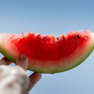 person holding watermelon to sky