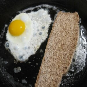 cast iron pan with eggs and bread