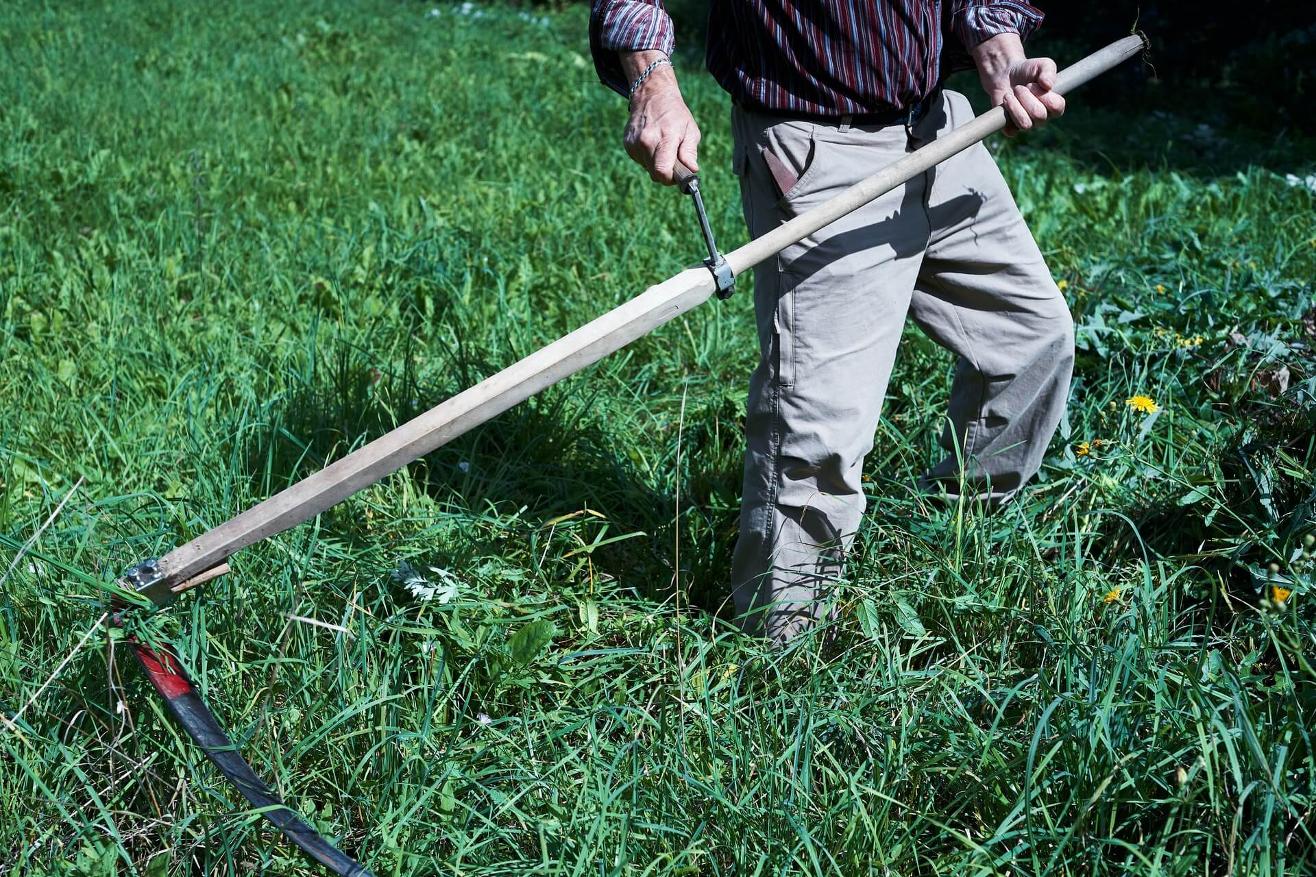 man holding a scythe - off-grid tools