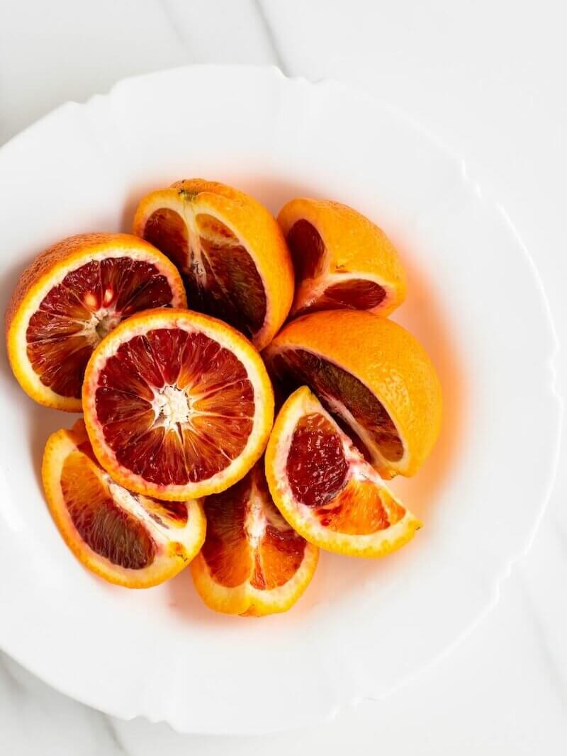 fatias de fruta laranja na placa de cerâmica branca