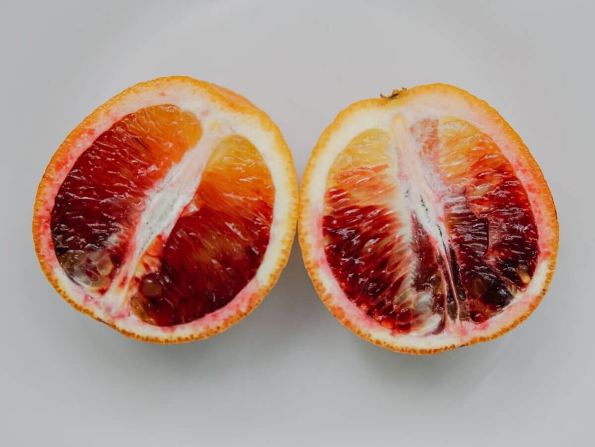 sliced blood orange fruit on white surface